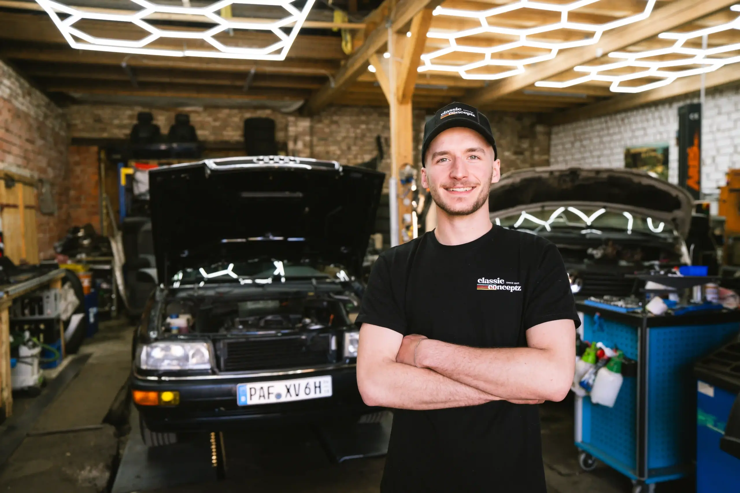 Louis von Classic Conceptz vor geöffneter Motorhaube in der Werkstatt bei Ingolstadt